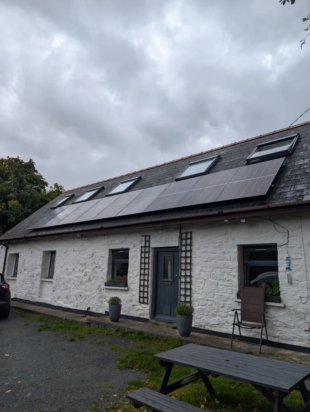 A rural stone cottage with solar panels on the roof
